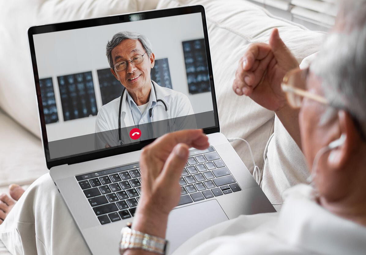 An older adult using a laptop for a video appointment